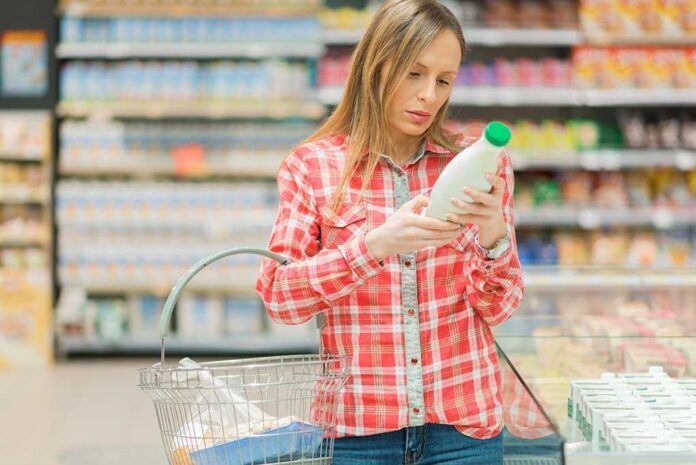 1031614558 featured image Woman reading label in grocery store aisle