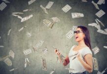 Woman with smartphone surrounded by falling money