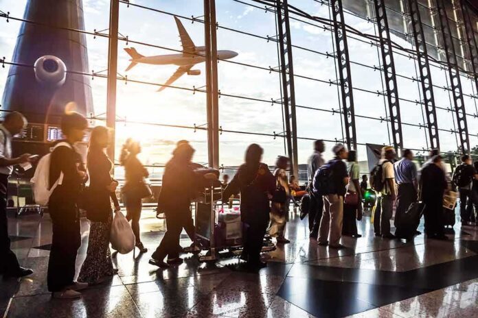 210042967 featured image Passengers waiting at airport gate with airplane outside window.