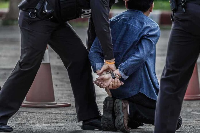 659470504 featured image Person kneeling with hands cuffed behind back