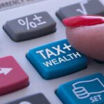 Finger pressing tax calculator button.