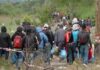 People walking on a path carrying bags outdoors
