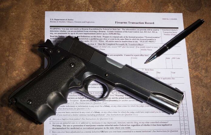 1026045637 featured image Gun and pen on firearm transaction form