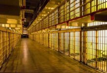 Empty hallway between rows of prison cells
