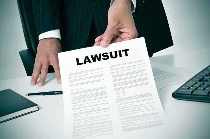189871757 featured image Person holding a document titled LAWSUIT in office