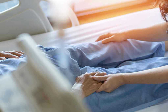 1921764251 Hospital patient holding visitor's hand reassuringly