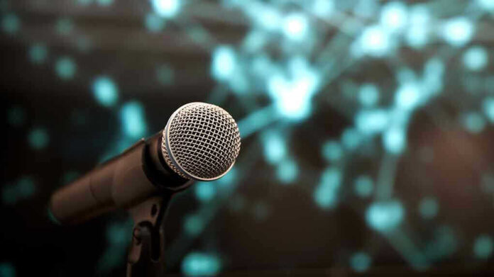 1934847146 Microphone with abstract, blurred blue background
