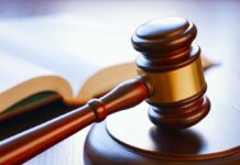 Gavel resting on sounding block beside open book