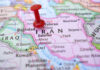 Red pushpin marking Iran on a map