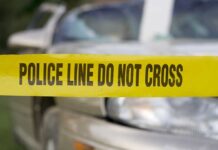 Yellow police tape in front of a car