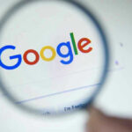 Google logo viewed through a magnifying glass