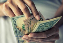 Person holding multiple dollar bills