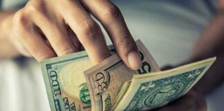 Person holding multiple dollar bills