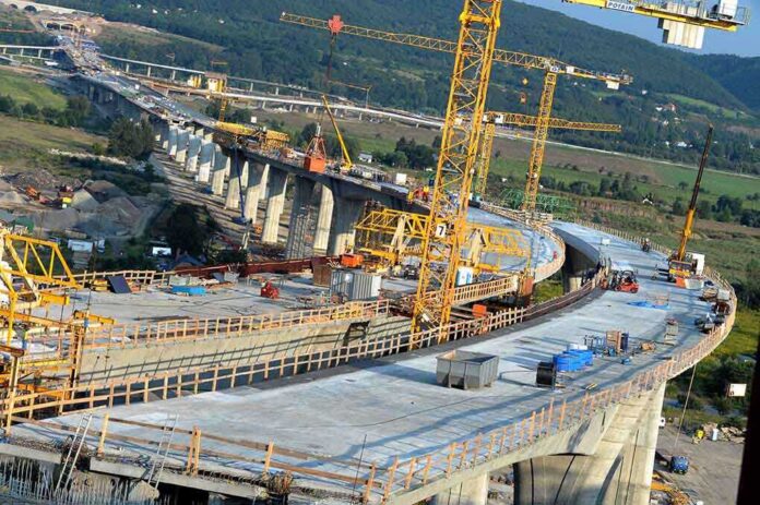 shutterstock_37230340.jpg Construction of a large bridge with cranes and machinery in operation