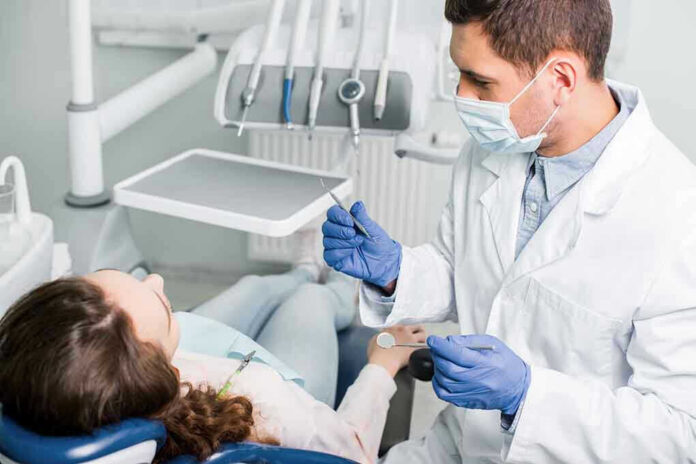 Dentist examining a patient in a dental chair.