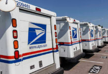 Row of USPS mail delivery trucks parked