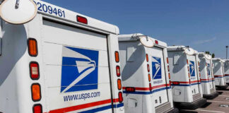 Row of USPS mail delivery trucks parked