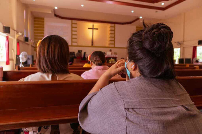 1773600770 People sitting in church pews during service.