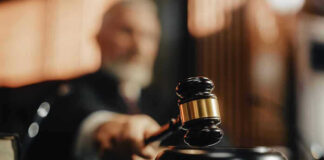 Judge using gavel in a courtroom setting.