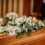 Flower arrangement on a wooden casket at a funeral