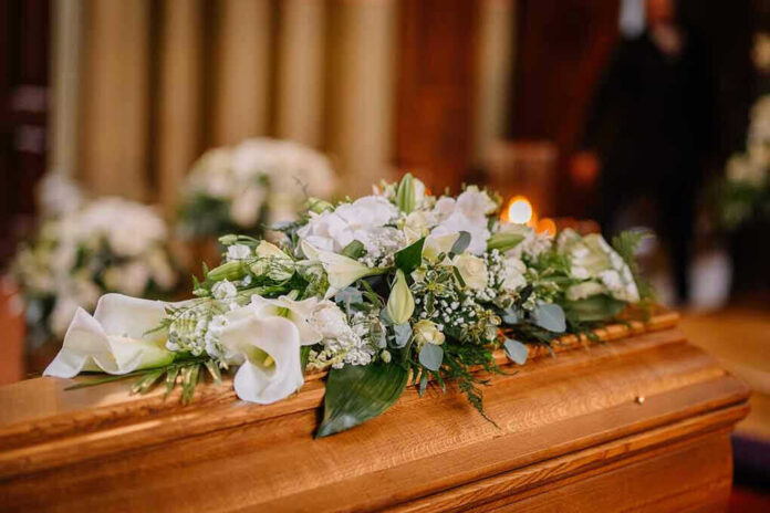 Flower arrangement on a wooden casket at a funeral
