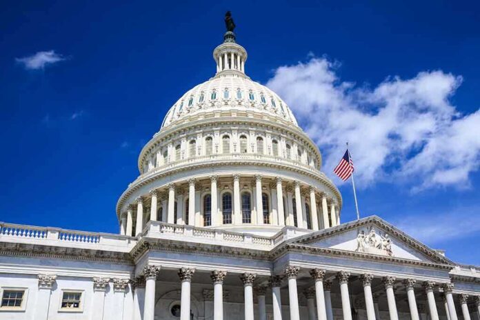 The US Capitol building with a dome and American flag against a blue sky
