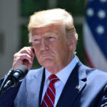 Political Heavyweights ERUPT After Trump’s Jab Man in a suit adjusting an earpiece.