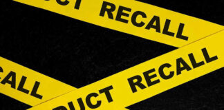 Yellow tape with product recall text on black background.