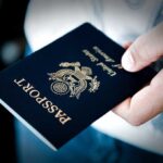 Passport Panic Erupts Mid-Flight – COMPLETE MAYHEM! A person holding a United States passport with a dark background