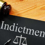 ANOTHER Trump Nemesis INDICTED—Justice System Flips Gavel next to indictment document on wooden table.