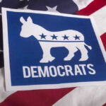 Dem Candidate Refuses To Answer Question – Kamala 2.0? Democrats logo on American flag background