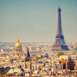 A panoramic view of Paris featuring the Eiffel Tower and a golden dome