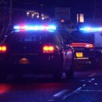 Brutal Attack on Mayor-Stabbed Multiple Times! Police cars with flashing lights at a nighttime scene near a motel