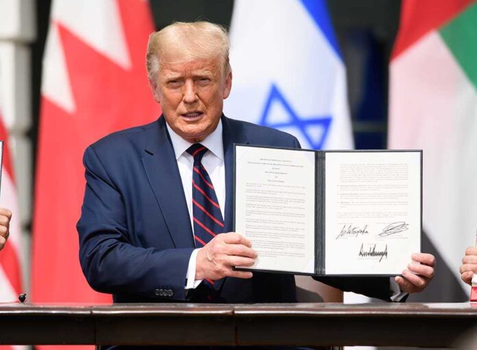 A man in a suit holding a signed document during a signing ceremony