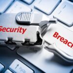 A padlock with the words Security and Breach on a computer keyboard