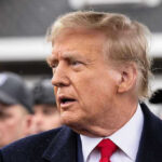 Trump WILL Pardon Ex-Governor – Despite Federal Case Man in suit and red tie speaking outside.