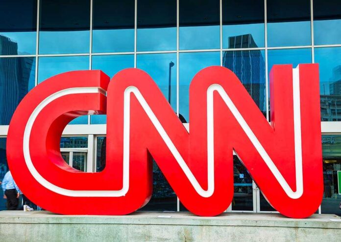 Large red CNN logo in front of a glass building