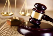 A wooden gavel and scales of justice on a table