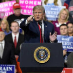 Trump Sends SHOCKING Memorial Day Message! Person speaking at rally with crowd behind podium