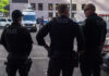 Three police officers standing on a city street.