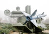 Military missile launcher with radar systems in a foggy field.