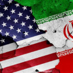 Iran SPEEDS UP Executions of Political Prisoners! Cracked American and Iranian flags painted on a wall.
