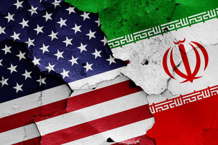1152300314 Cracked American and Iranian flags painted on a wall.