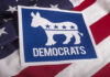 Dem Candidate PULLS Gun In Office – Entire Staff SHOOK! Democrats logo on American flag background