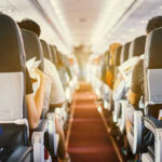 Passengers seated inside an airplane cabin.