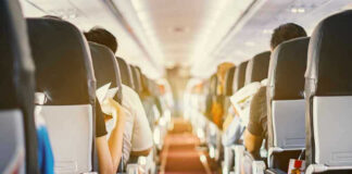 Passengers seated inside an airplane cabin.