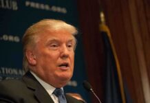 Trump REWARDS Mortgage Boss Top Position! A public figure speaking at a podium during a press conference