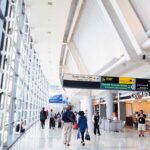 Airports’ Four-Letter Code You Don’t Want On Your Boarding Pass Interior of an airport terminal with travelers and signage