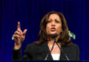 Kamala Makes Desperate Move in Pathetic 2028 Plan Woman speaking passionately at a podium, gesturing upward.