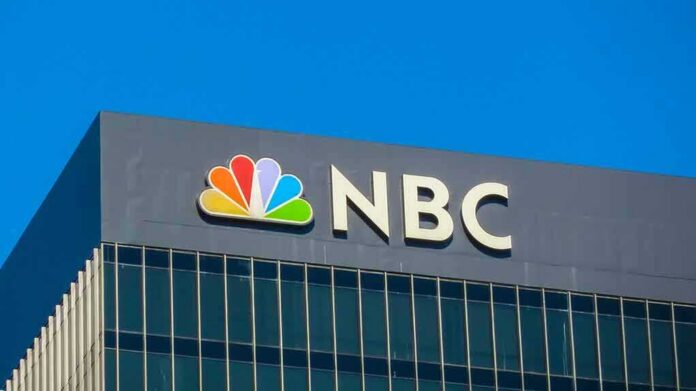 NBC logo displayed on a corporate building against a blue sky